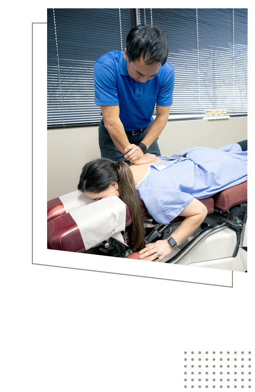 Dr. Zen Matsuda adjusting a patient's back during an appointment
