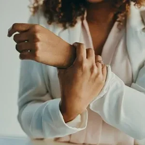 A woman supporting her wrist, experiencing carpal tunnel