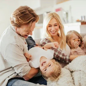 A family of four laughing and playing together